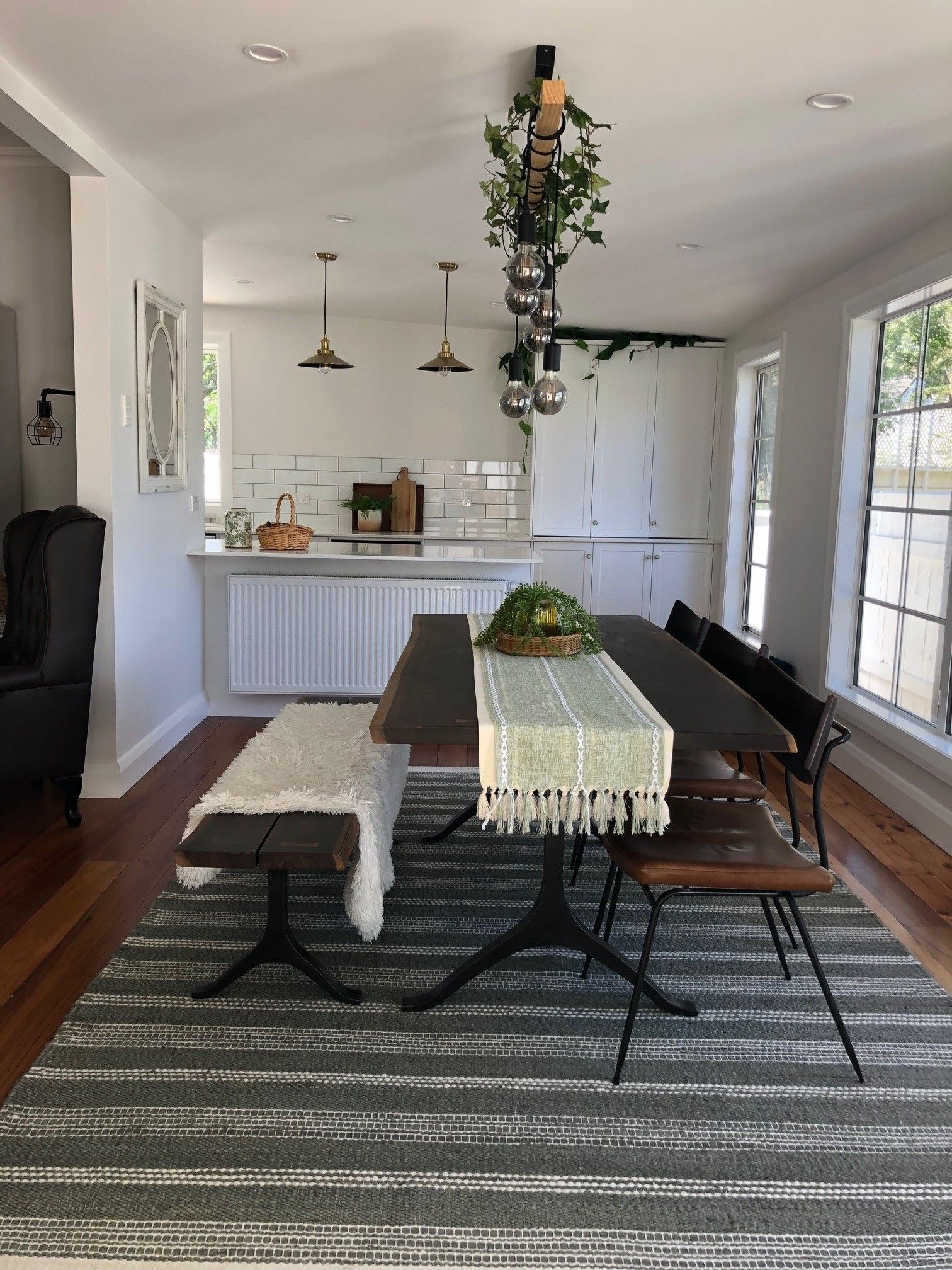 A dining room with a table and chairs and a rug.