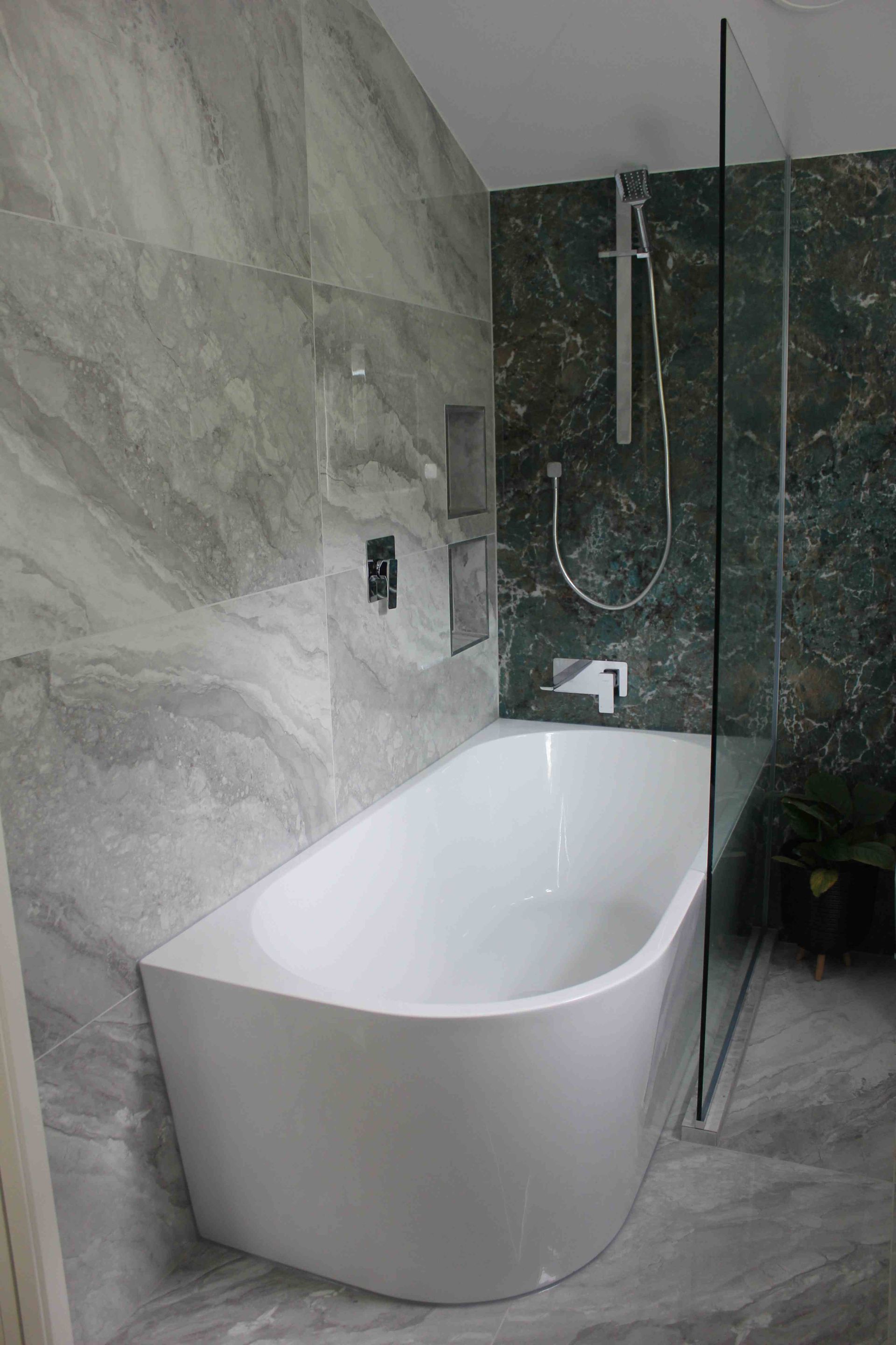 A bathroom with a bathtub and a walk in shower.