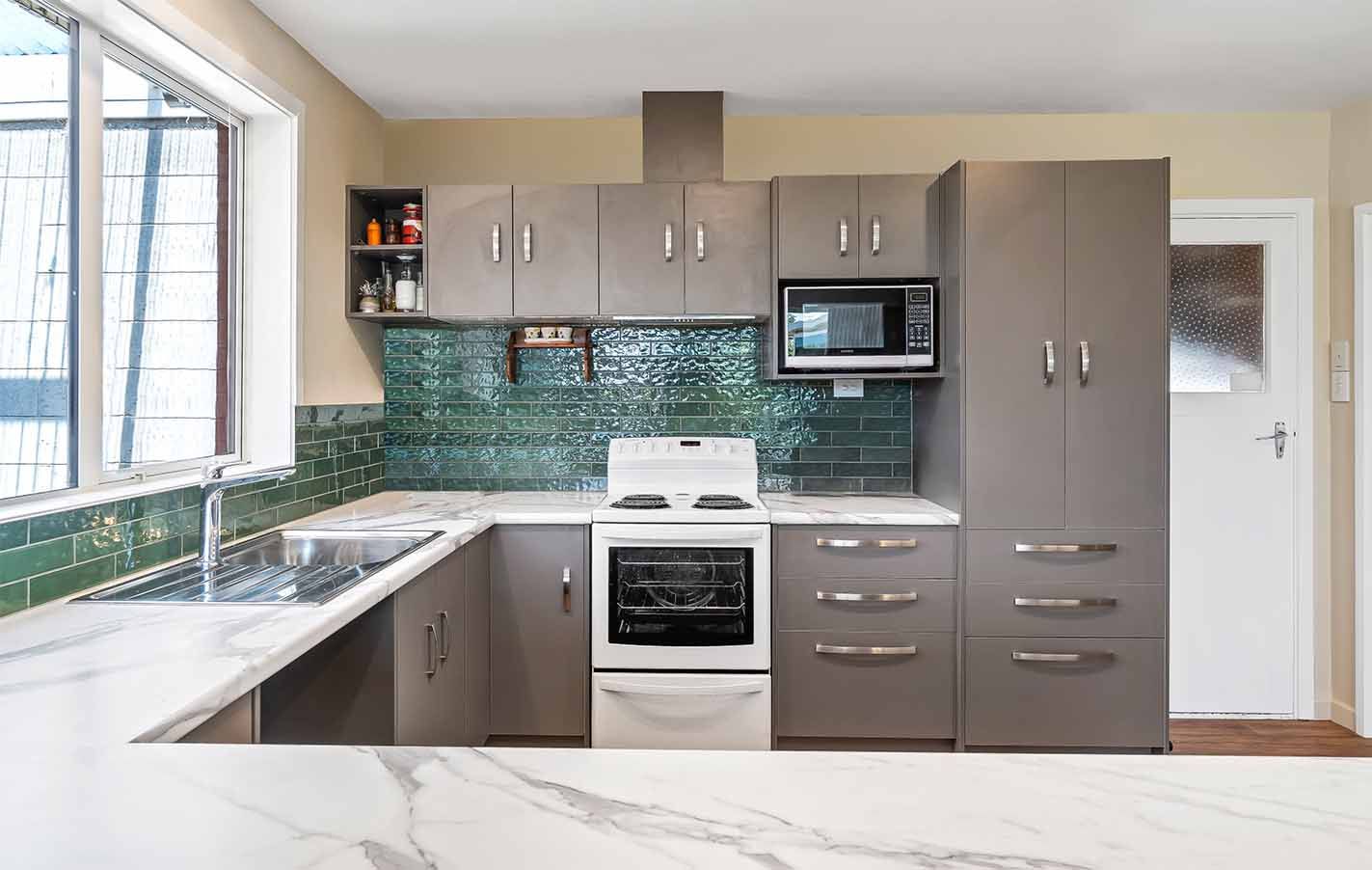 A kitchen with a stove , sink , and microwave.