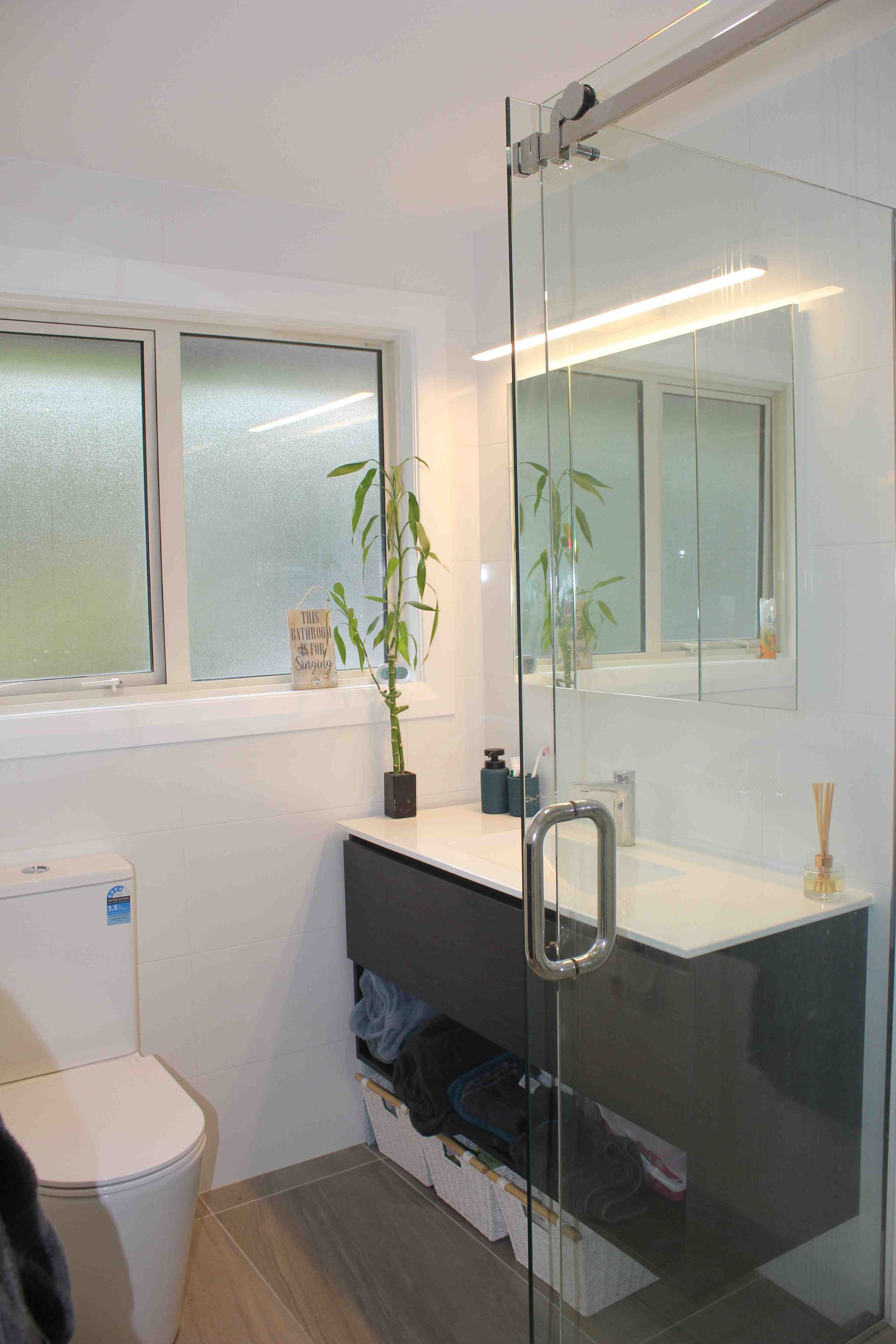 A bathroom with a toilet , sink , and shower.