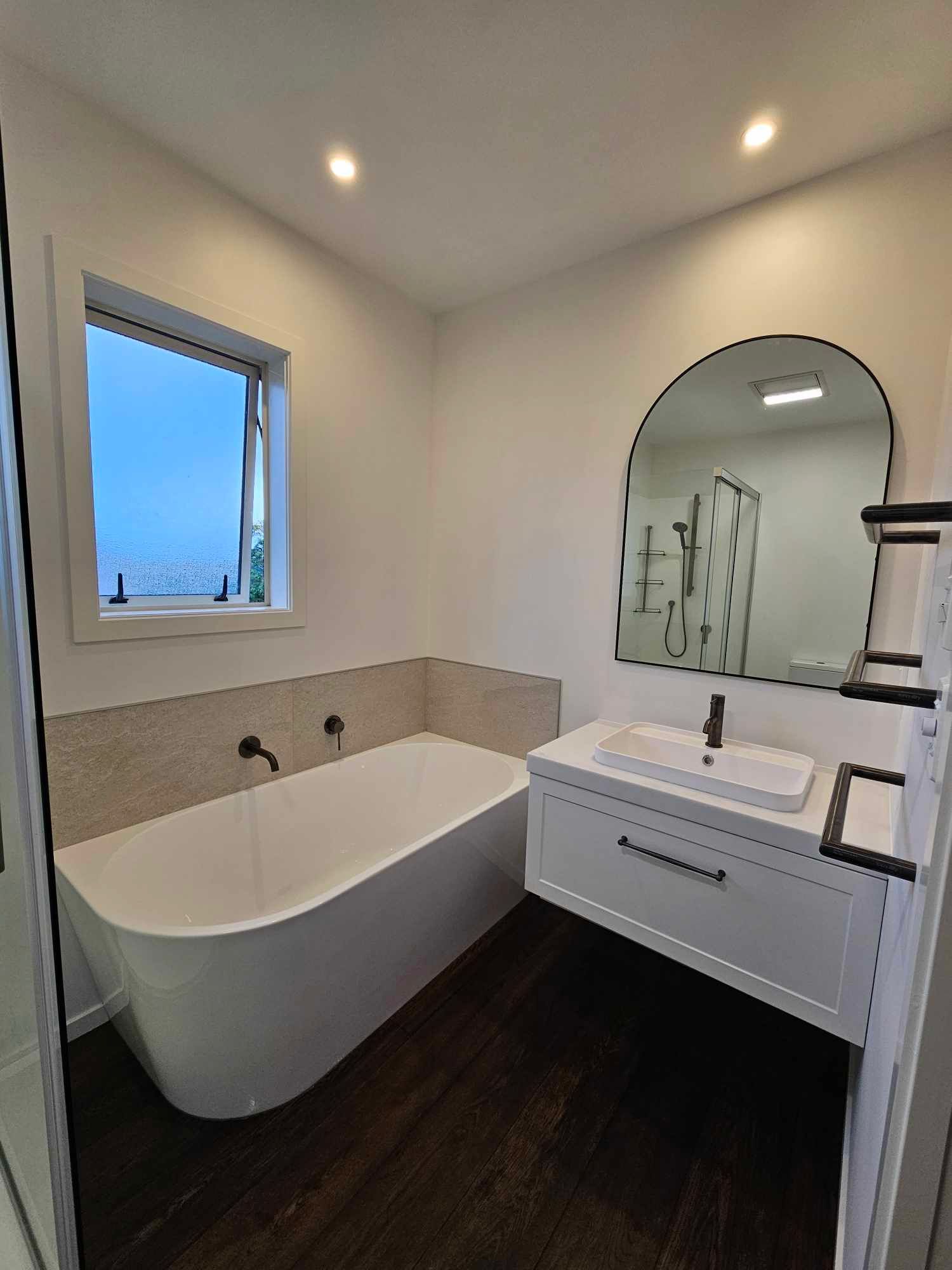 swanky bathroom with arch mirror
