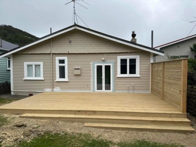 A small house with a wooden deck in front of it