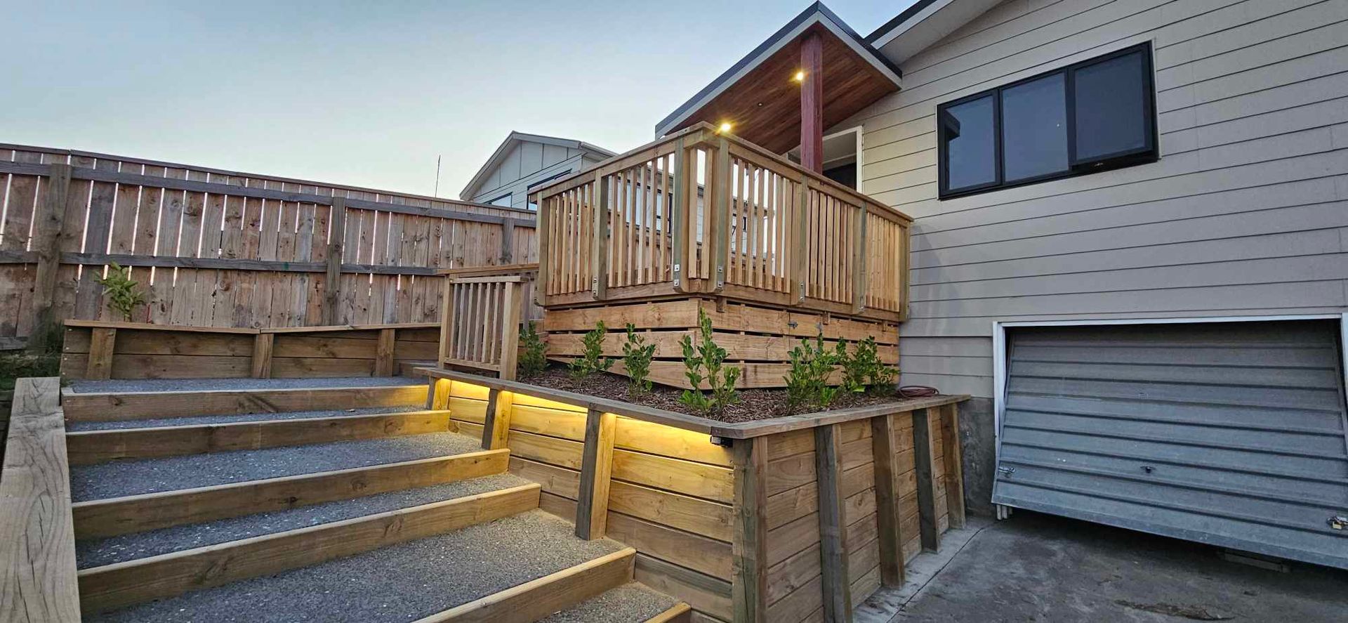 A house with a wooden deck and stairs leading up to it.