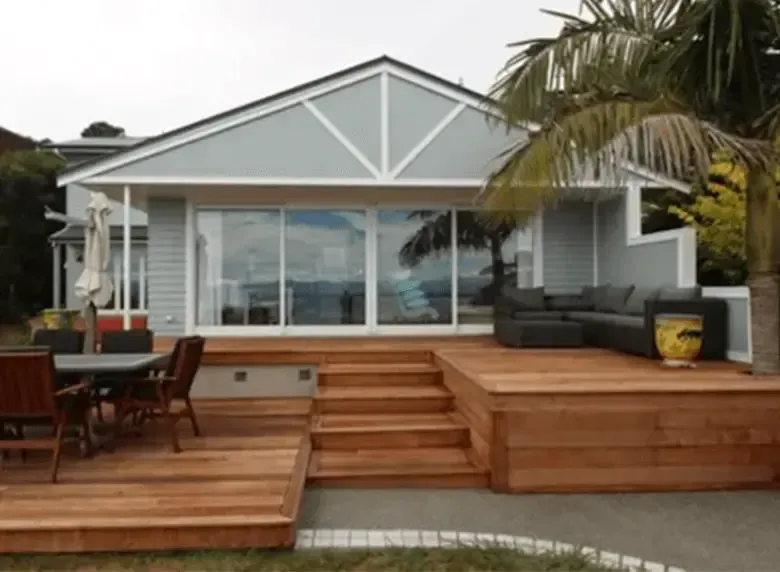 A house with a wooden deck and stairs in front of it