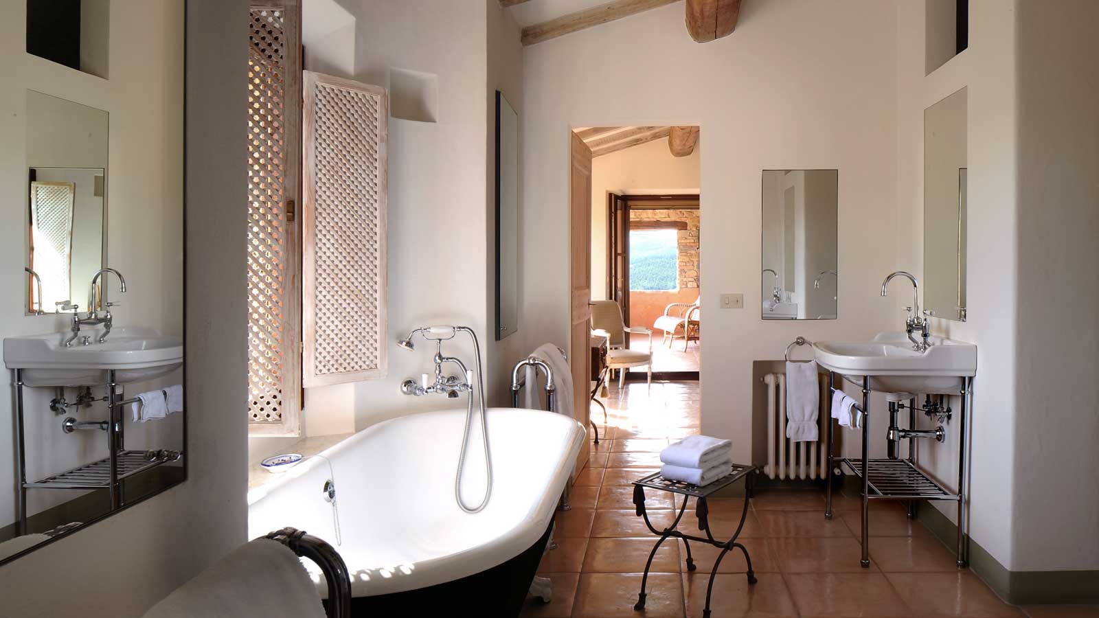 A bathroom with a tub , sinks and mirrors