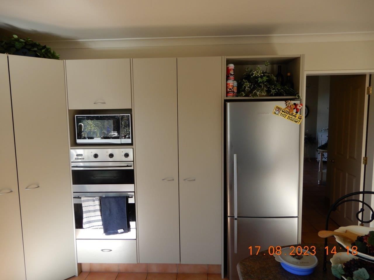 A kitchen with white cabinets and a stainless steel refrigerator