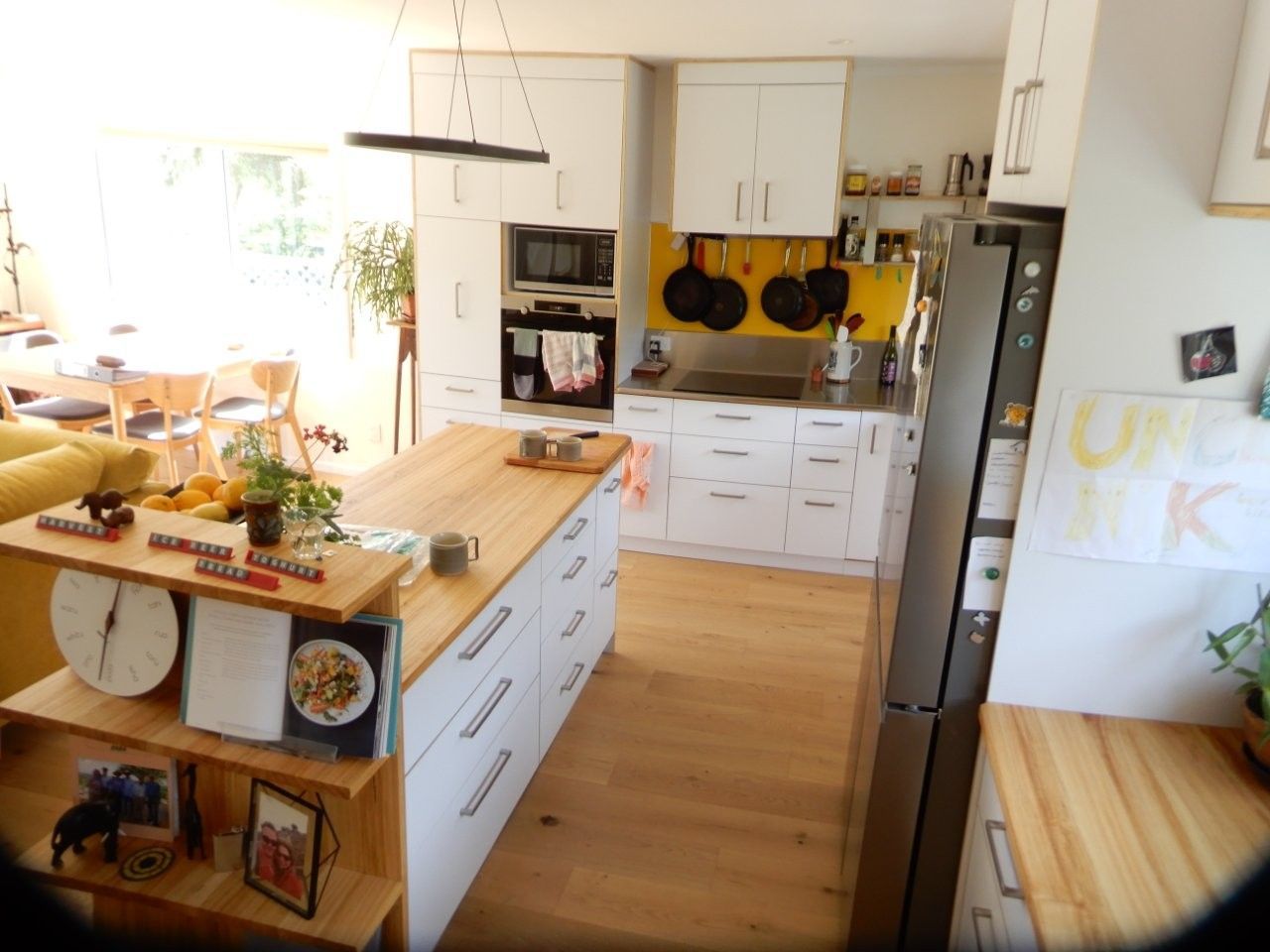 A kitchen with white cabinets and wooden counter tops