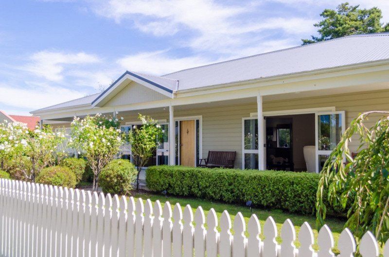 A house with a white picket fence in front of it.