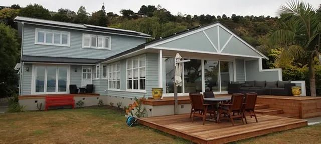 A large house with a wooden deck in front of it