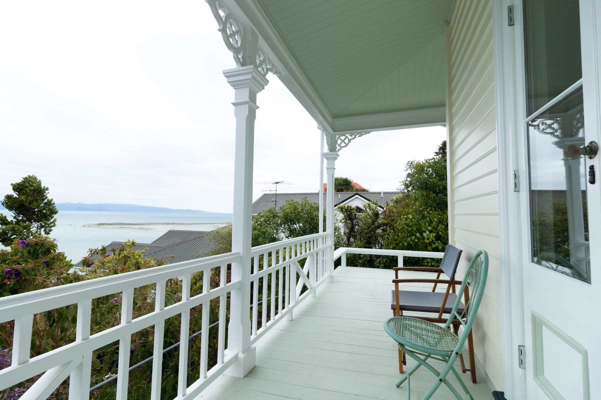 A porch with chairs and a view of the ocean