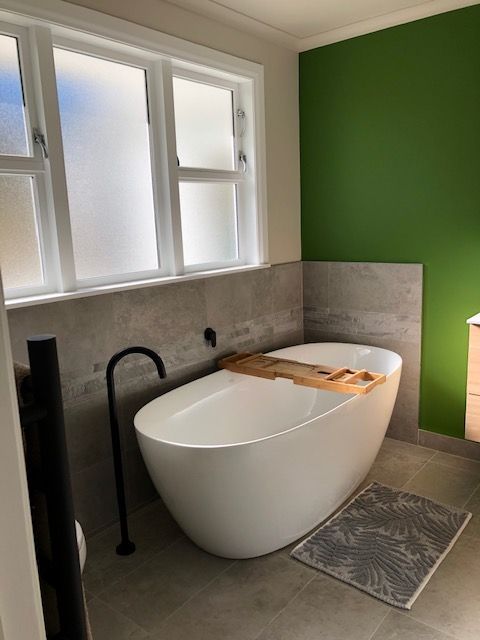 freestanding tub with tile and green background