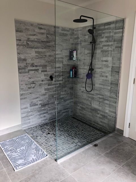 tiled walk in shower in grey tile and black shower