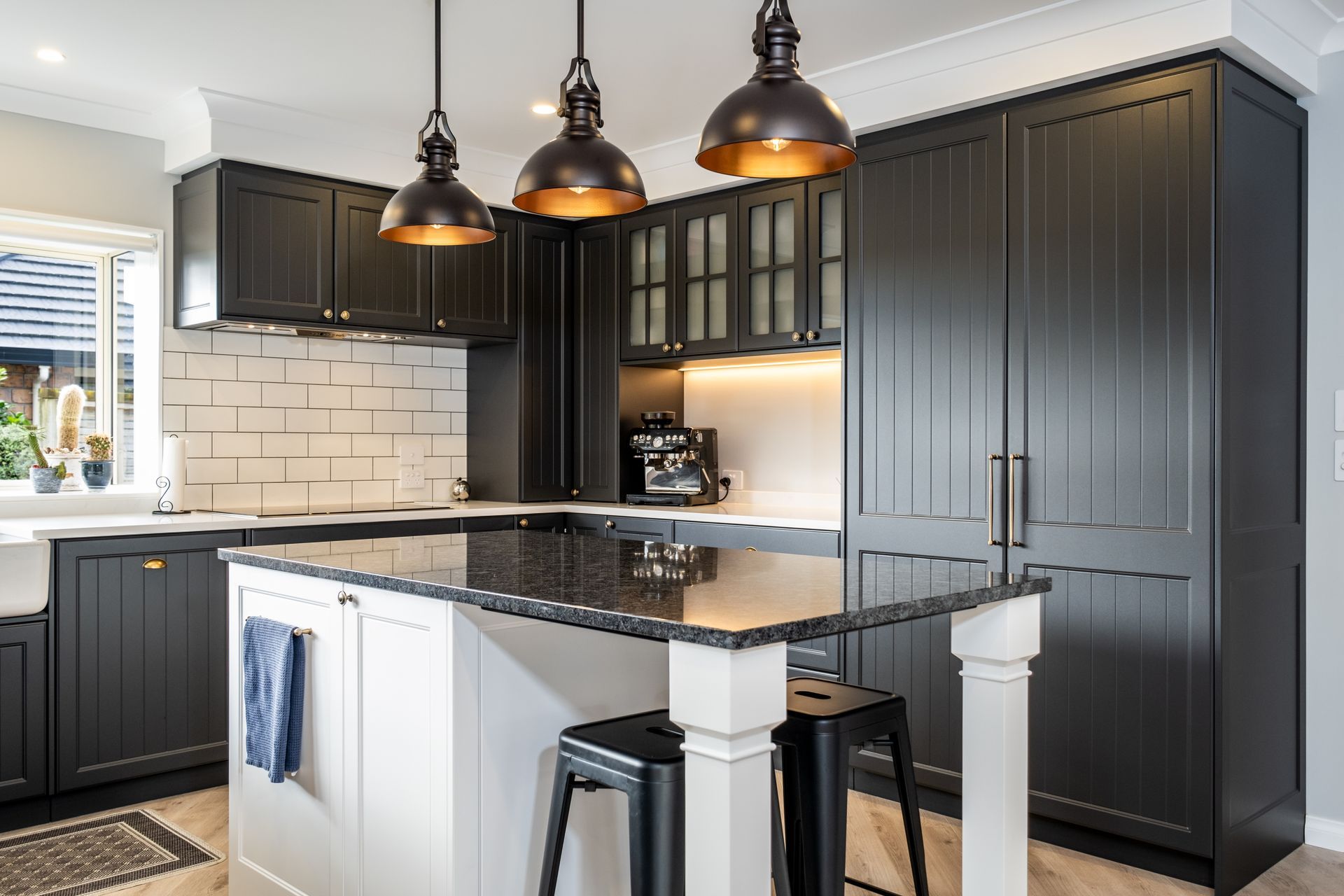 A kitchen with black cabinets and a black granite counter top.