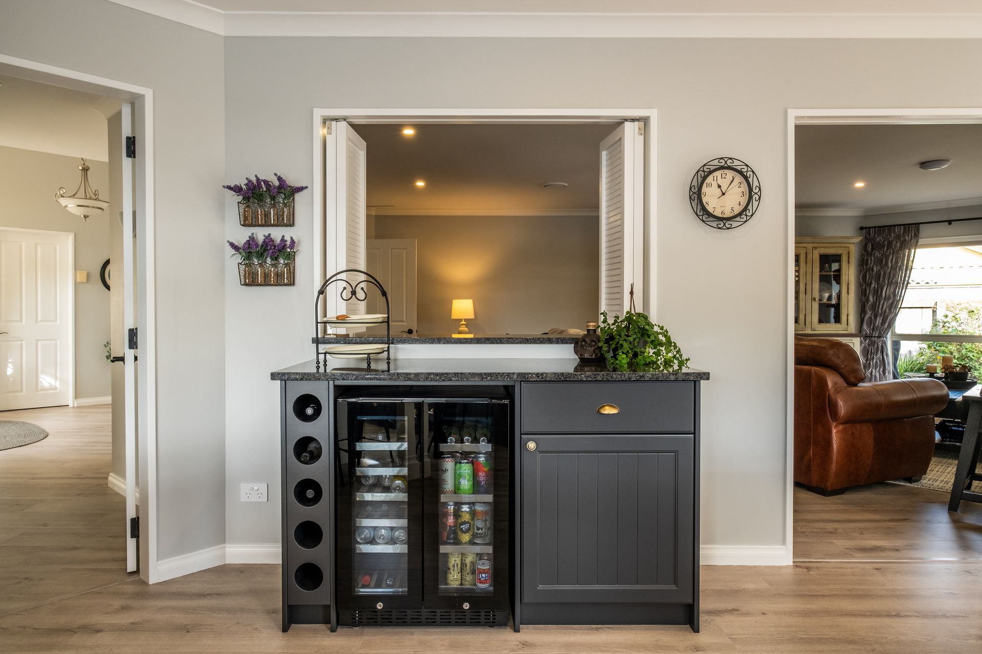 A kitchen with a bar and a clock on the wall.