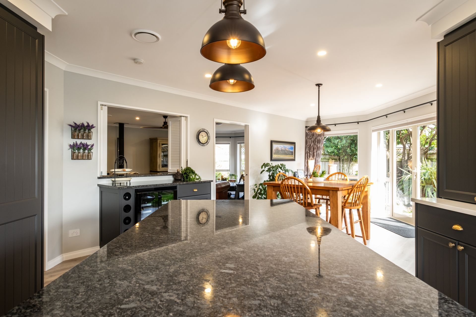 A kitchen with a large island and a dining room in the background.