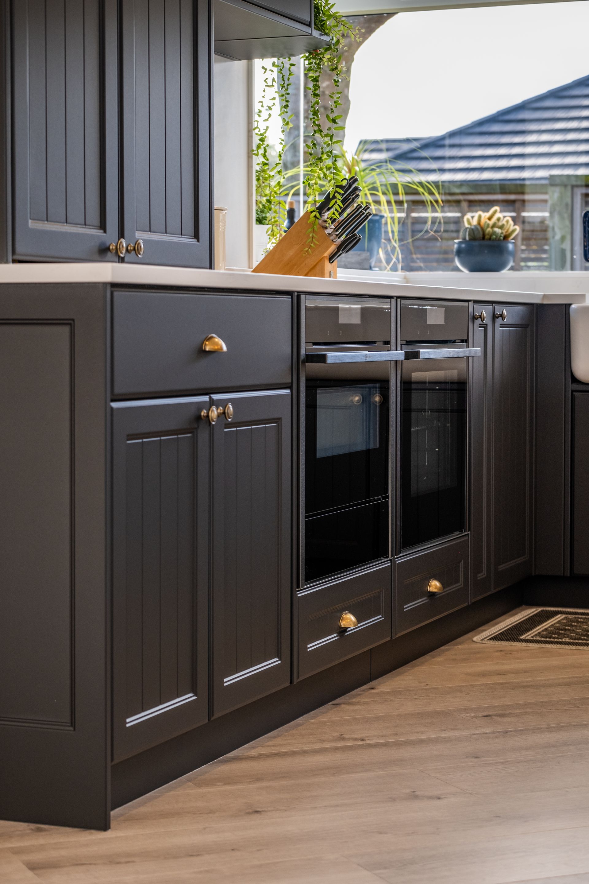 A kitchen with black cabinets and stainless steel appliances.