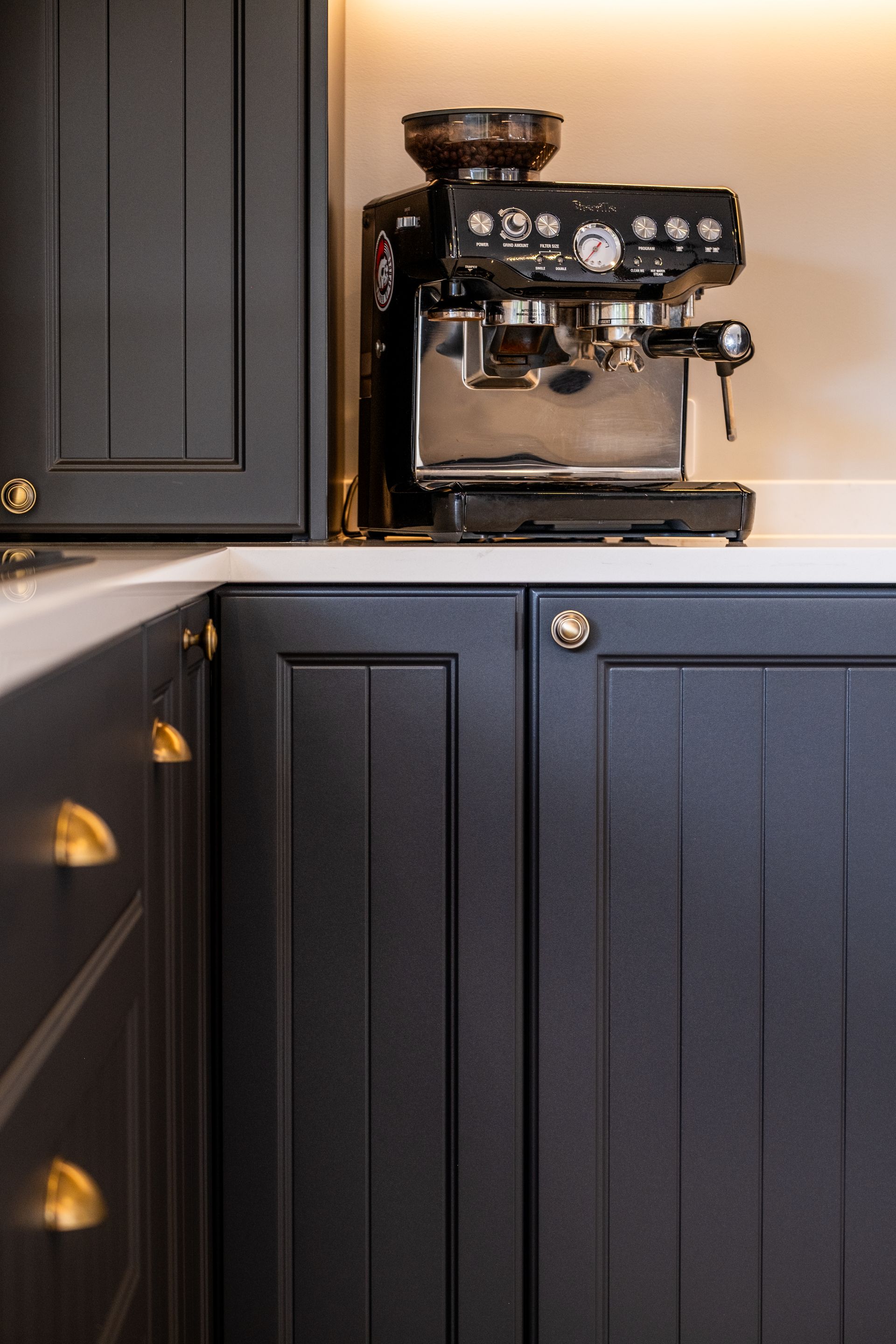 A coffee machine is sitting on a counter in a kitchen.