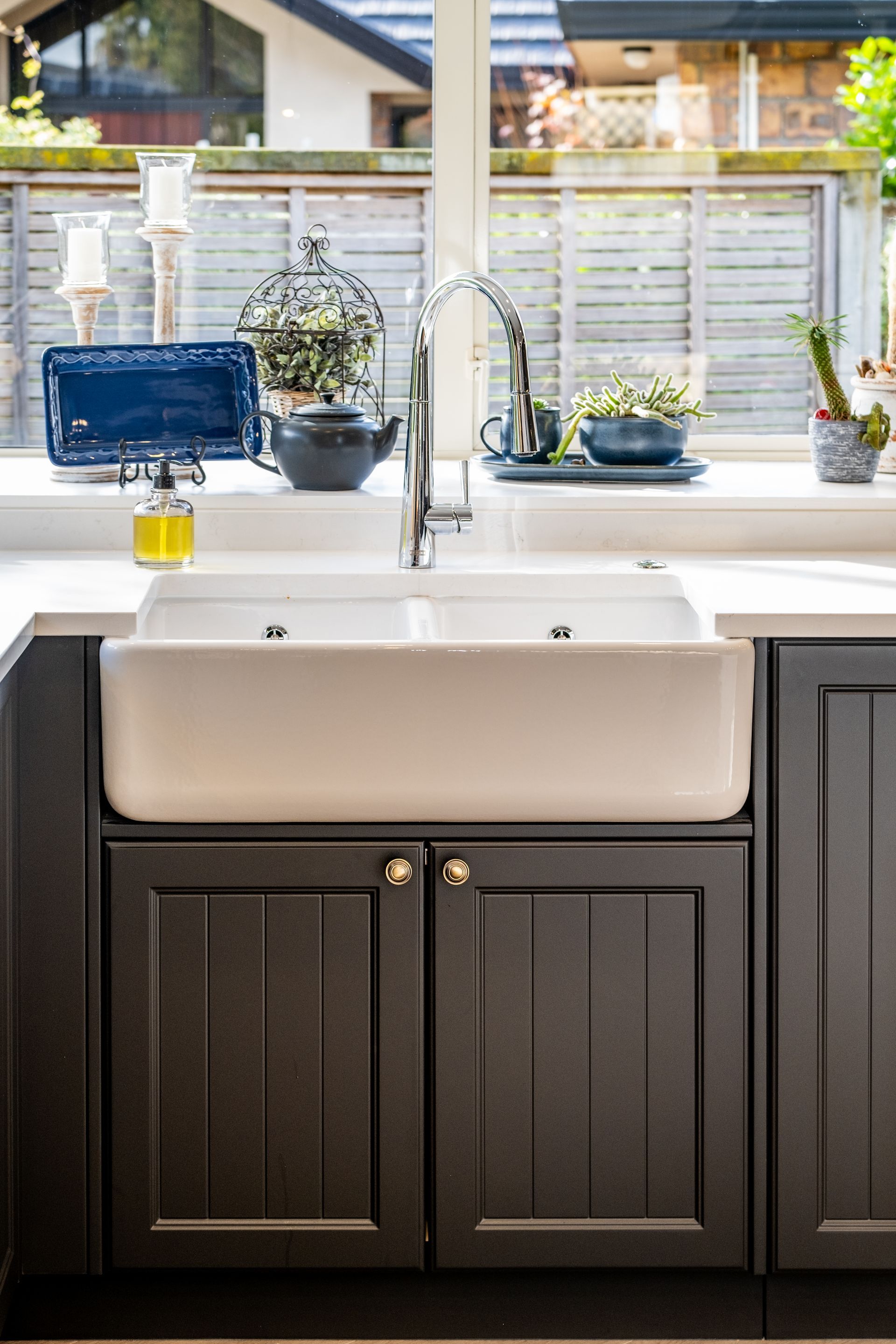 A kitchen sink is sitting under a window in a kitchen.