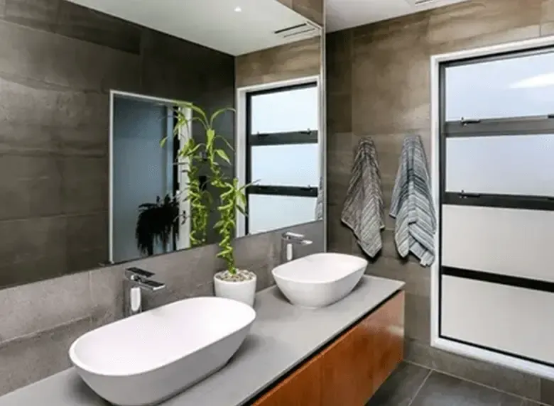 A bathroom with two sinks and a large mirror.