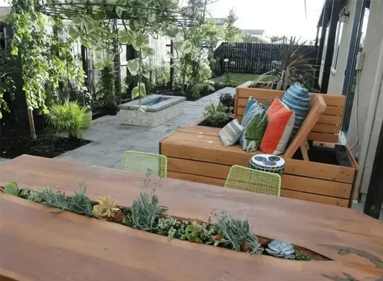 A wooden table with a planter in the middle of it