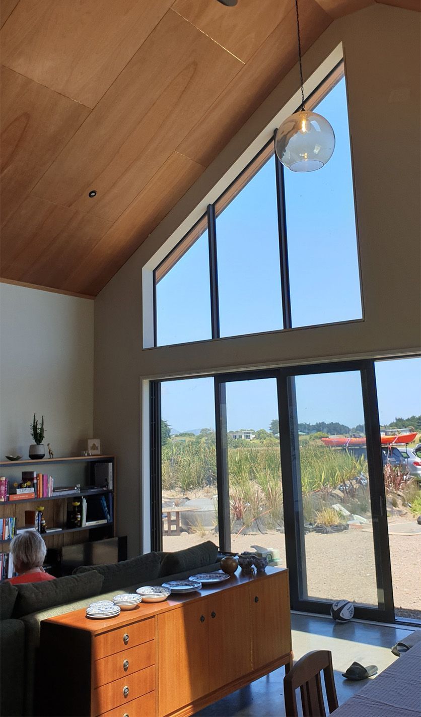 open plan living area with high ceiling and feature windows