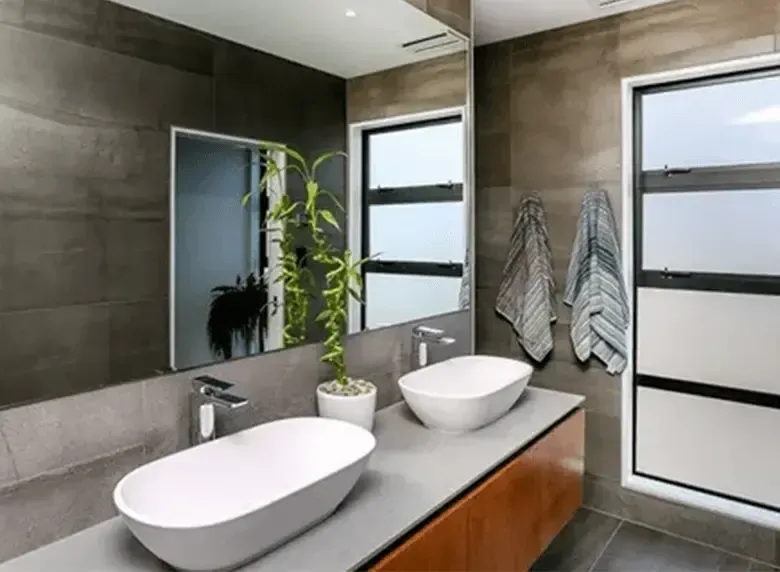 A bathroom with two sinks and a large mirror.