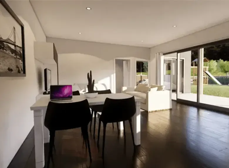 A living room with a table and chairs and a laptop on the table