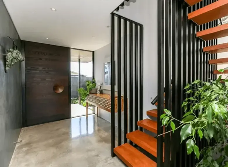 A hallway with stairs leading up to the second floor of a house.