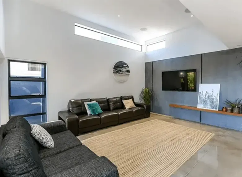 A living room with a couch , rug and television.