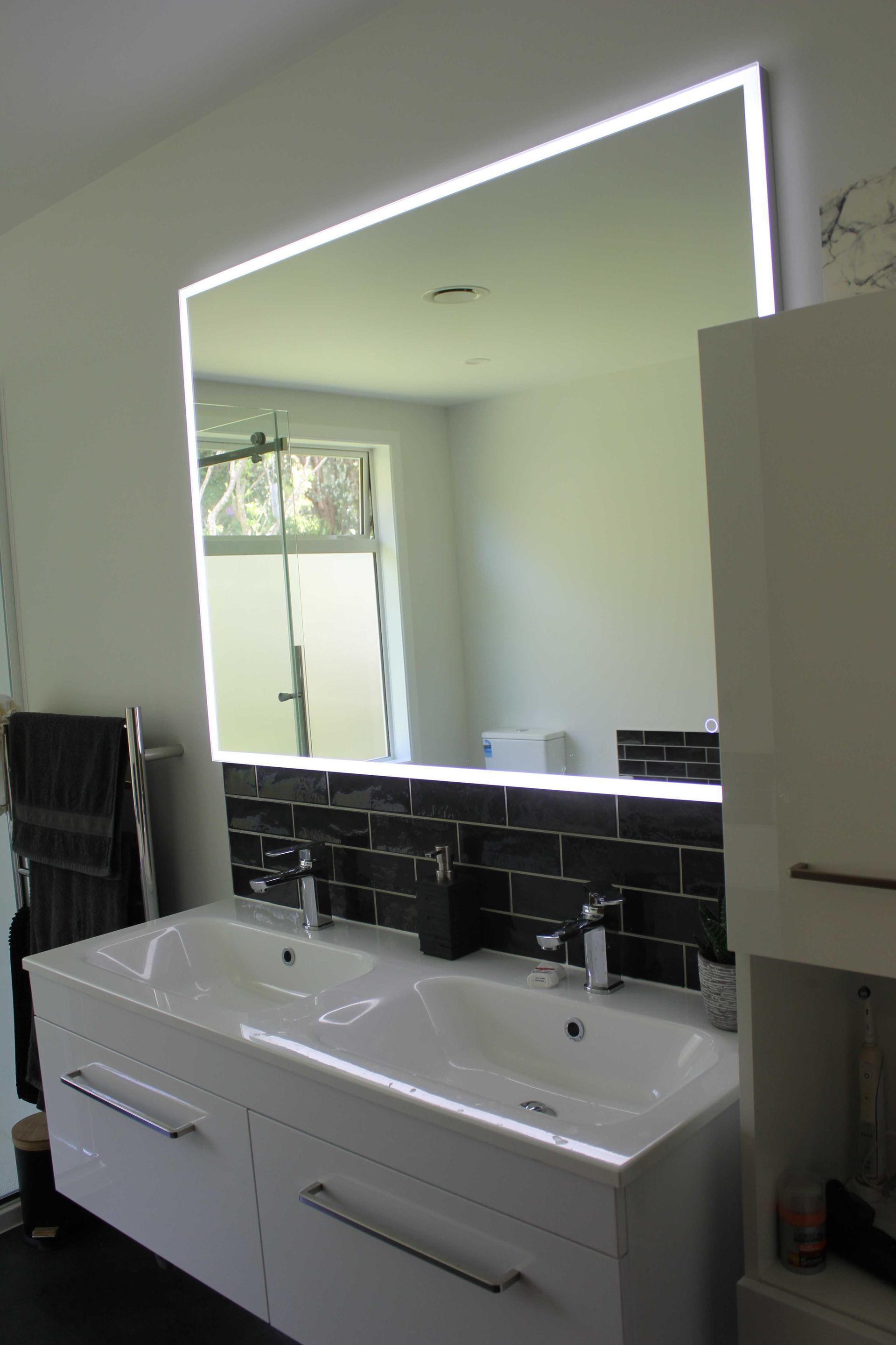 A bathroom with two sinks and a large mirror.