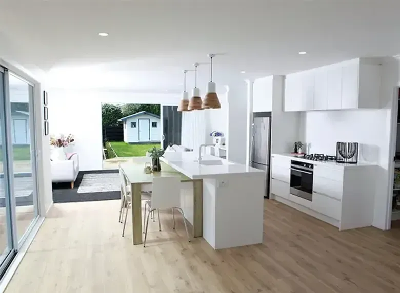 A kitchen with white cabinets and wooden floors