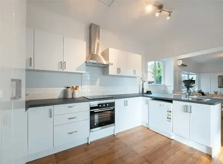 A kitchen with white cabinets and stainless steel appliances