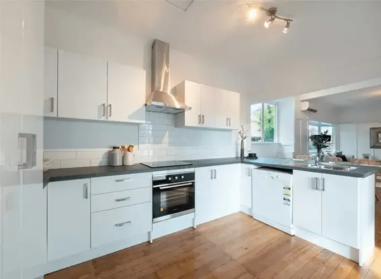 A kitchen with white cabinets and stainless steel appliances