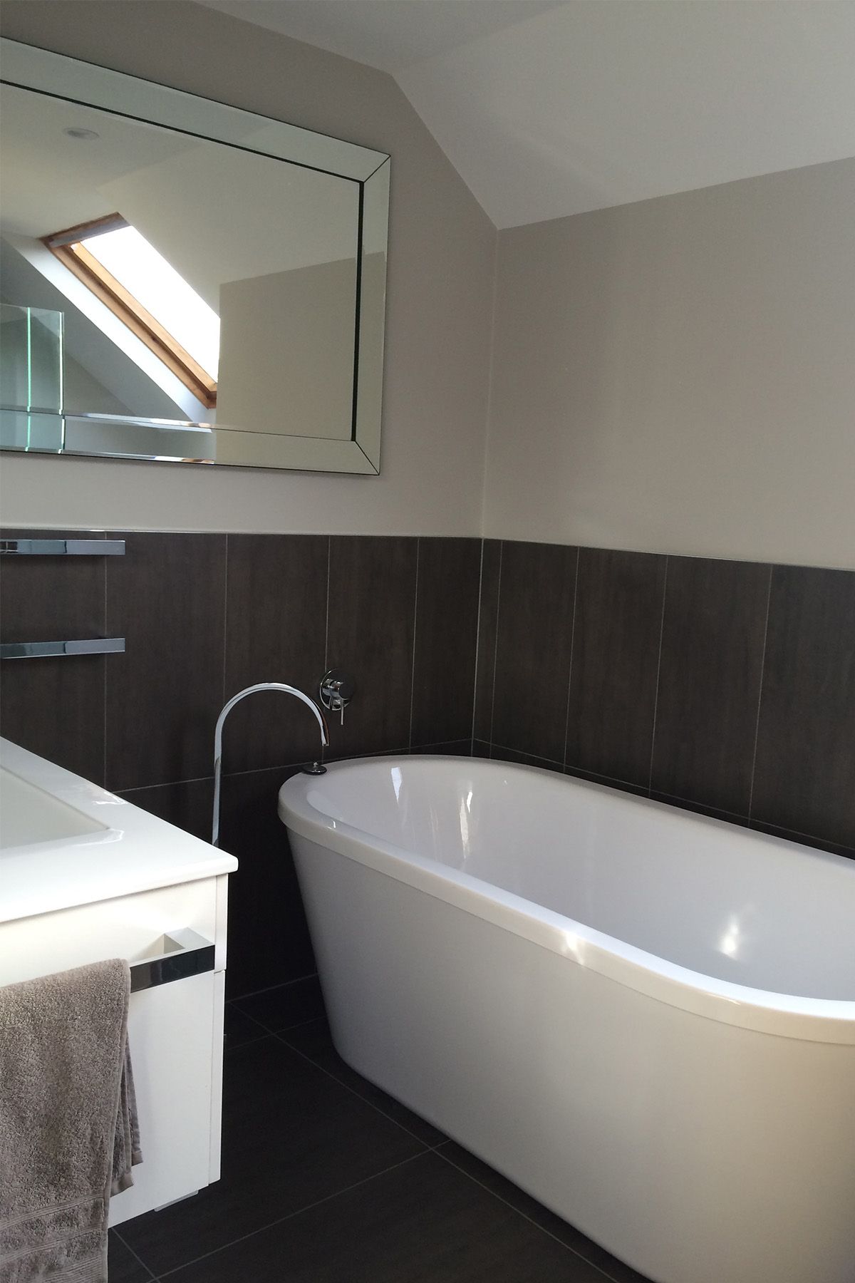 A bathroom with a bathtub and a large mirror