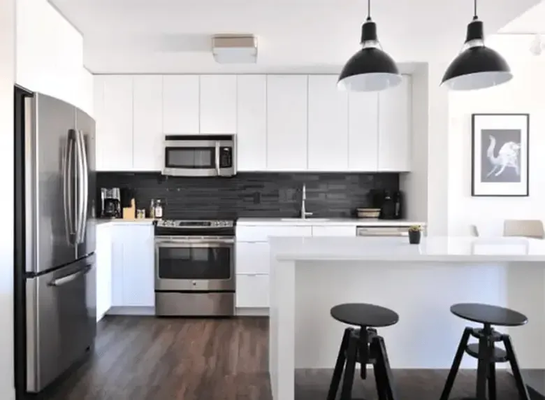 A kitchen with white cabinets and stainless steel appliances