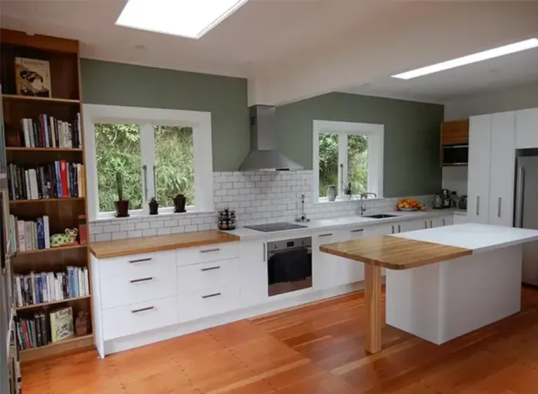 A kitchen with white cabinets and wooden floors