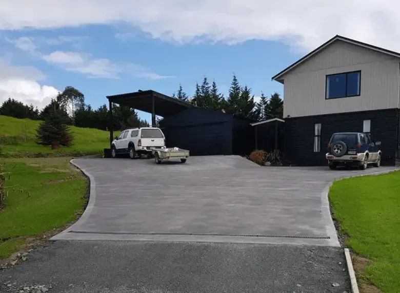 Two cars are parked in a driveway in front of a house.