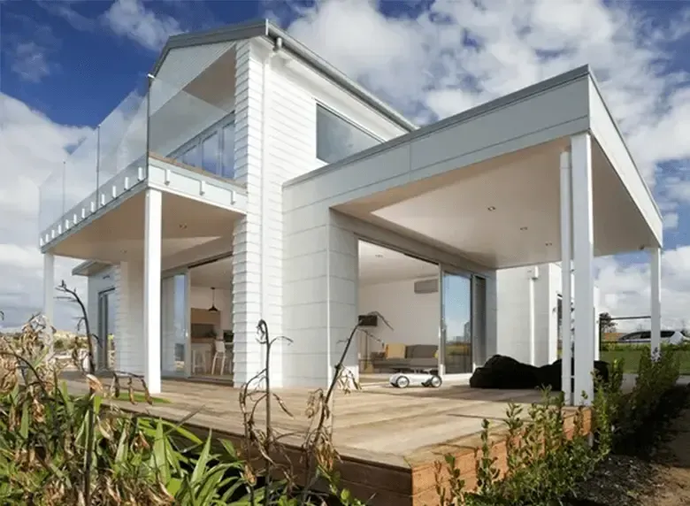 A white house with a balcony and sliding glass doors