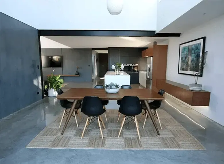 A dining room with a table and chairs and a rug