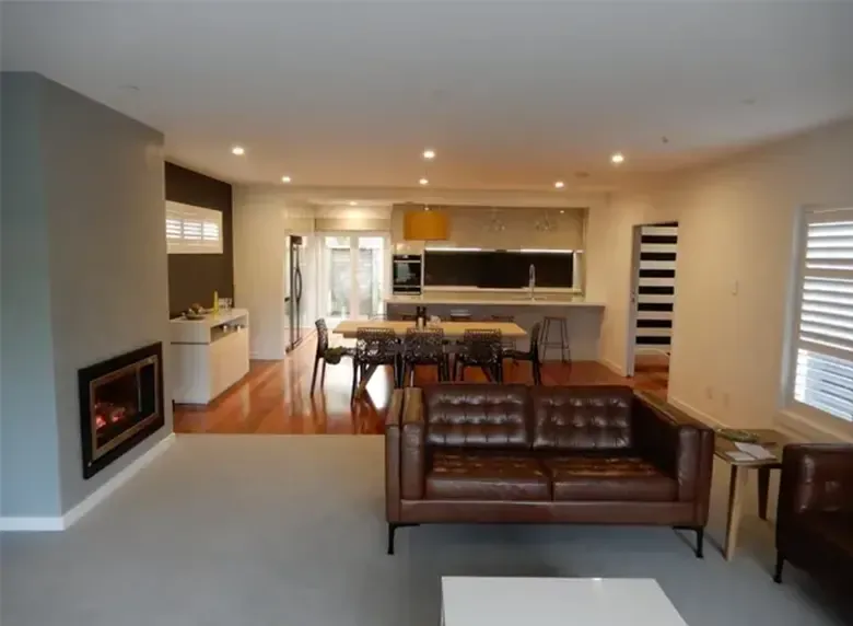 A living room with a brown couch and a fireplace