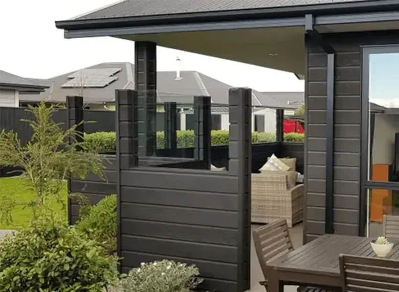 A patio with a table and chairs in front of a house.