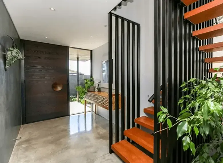 A hallway with stairs leading up to the second floor of a house.