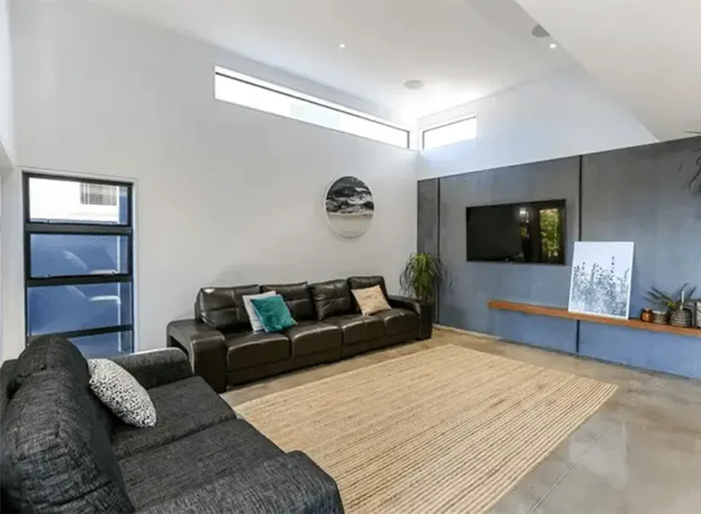 A living room with a couch , rug and television.