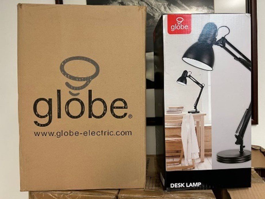 A globe desk lamp is in a cardboard box