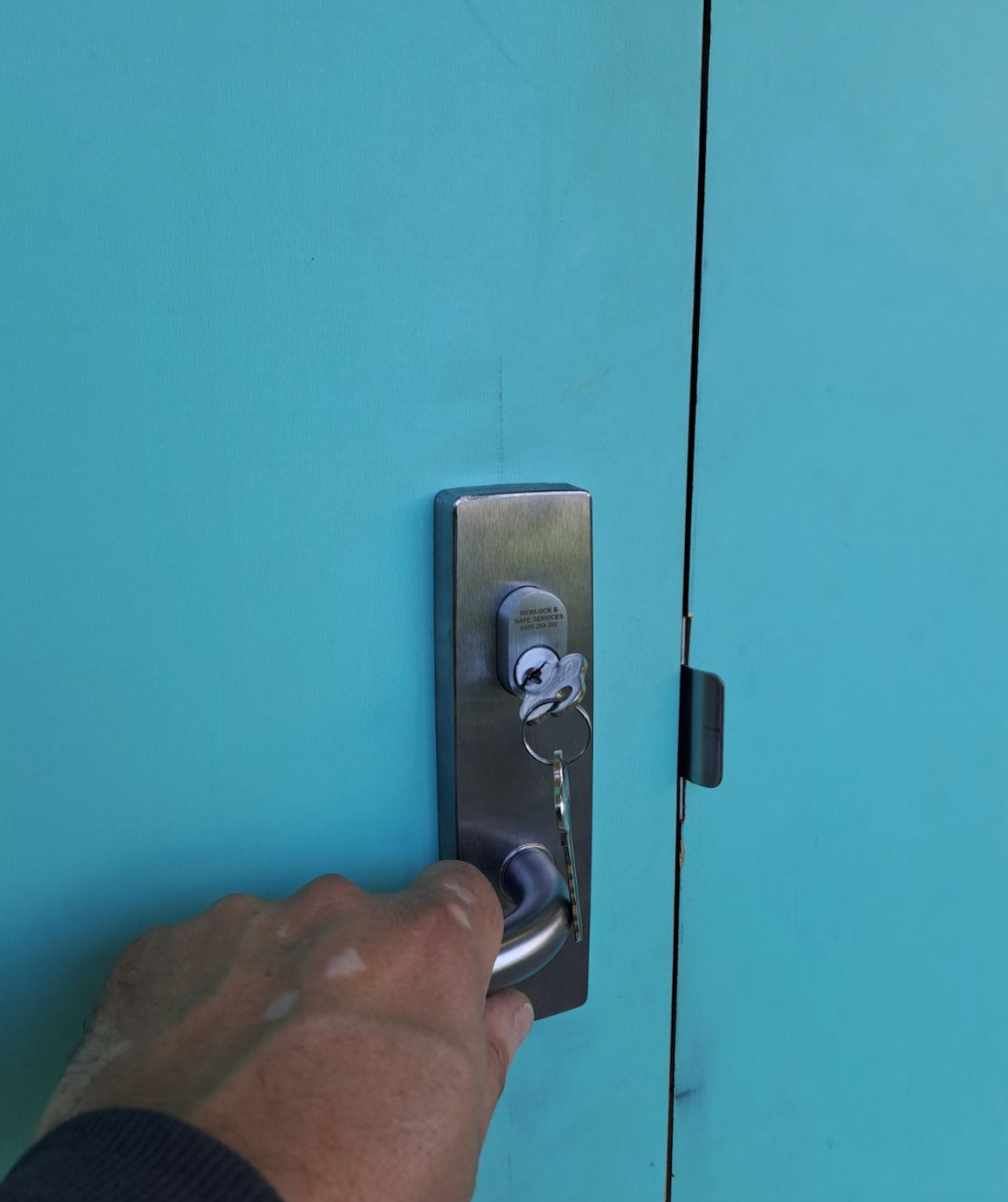 Man Using A Screwdriver To Fix A Door Lock — New Lock & Safe Services in Terang, VIC