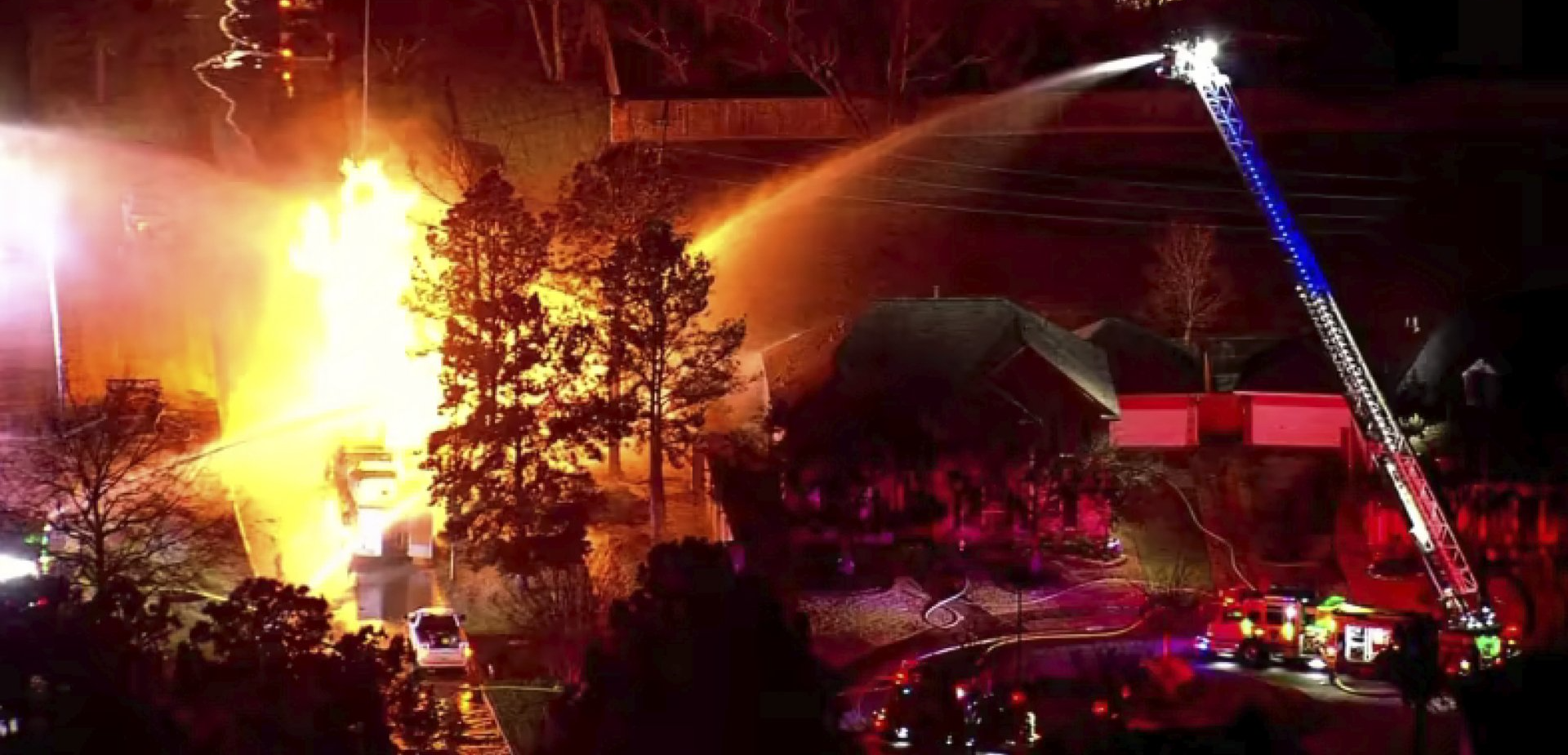 A fire truck is spraying water on a large fire.
