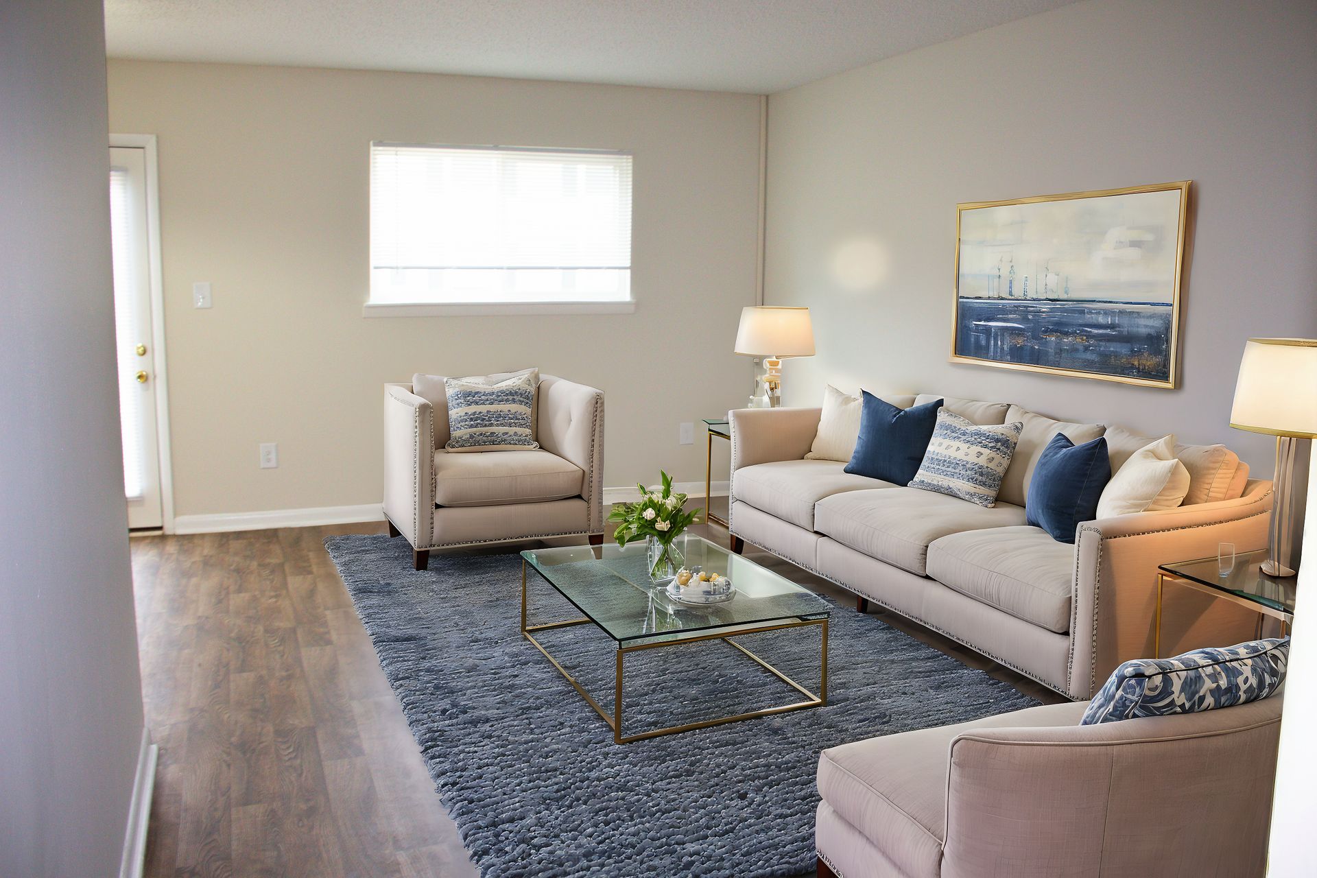 A living room with a couch , chair , coffee table and rug.