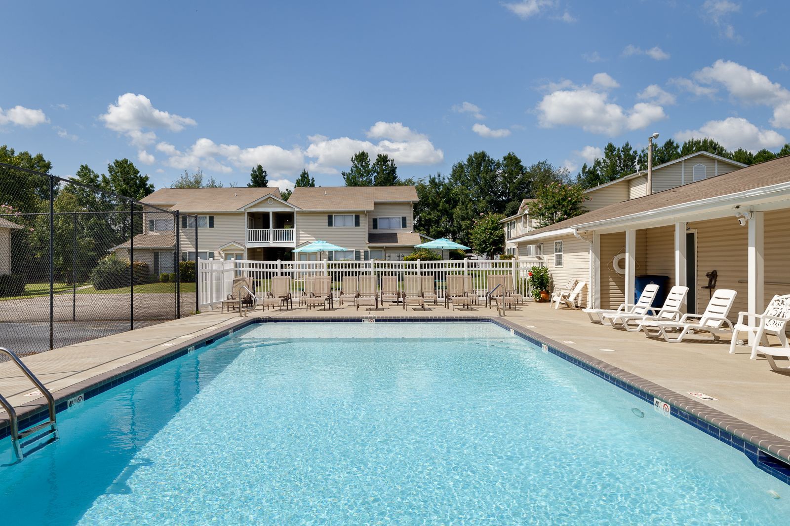 A large swimming pool with chairs and umbrellas around it