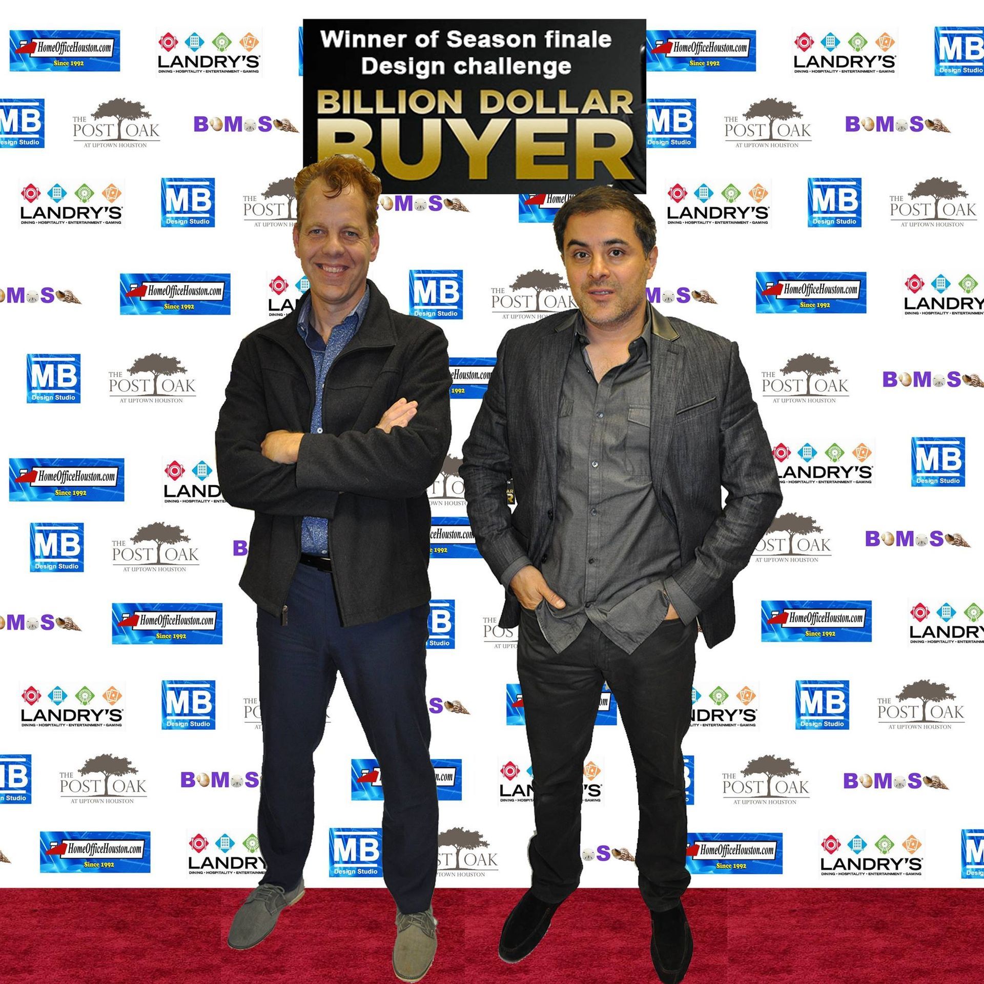 Two men stand on a red carpet. 