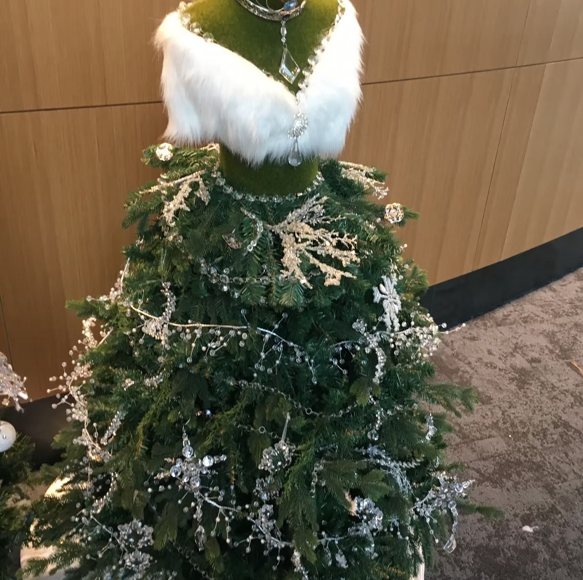 Christmas tree decorated as a white-trimmed dress with silver accents.